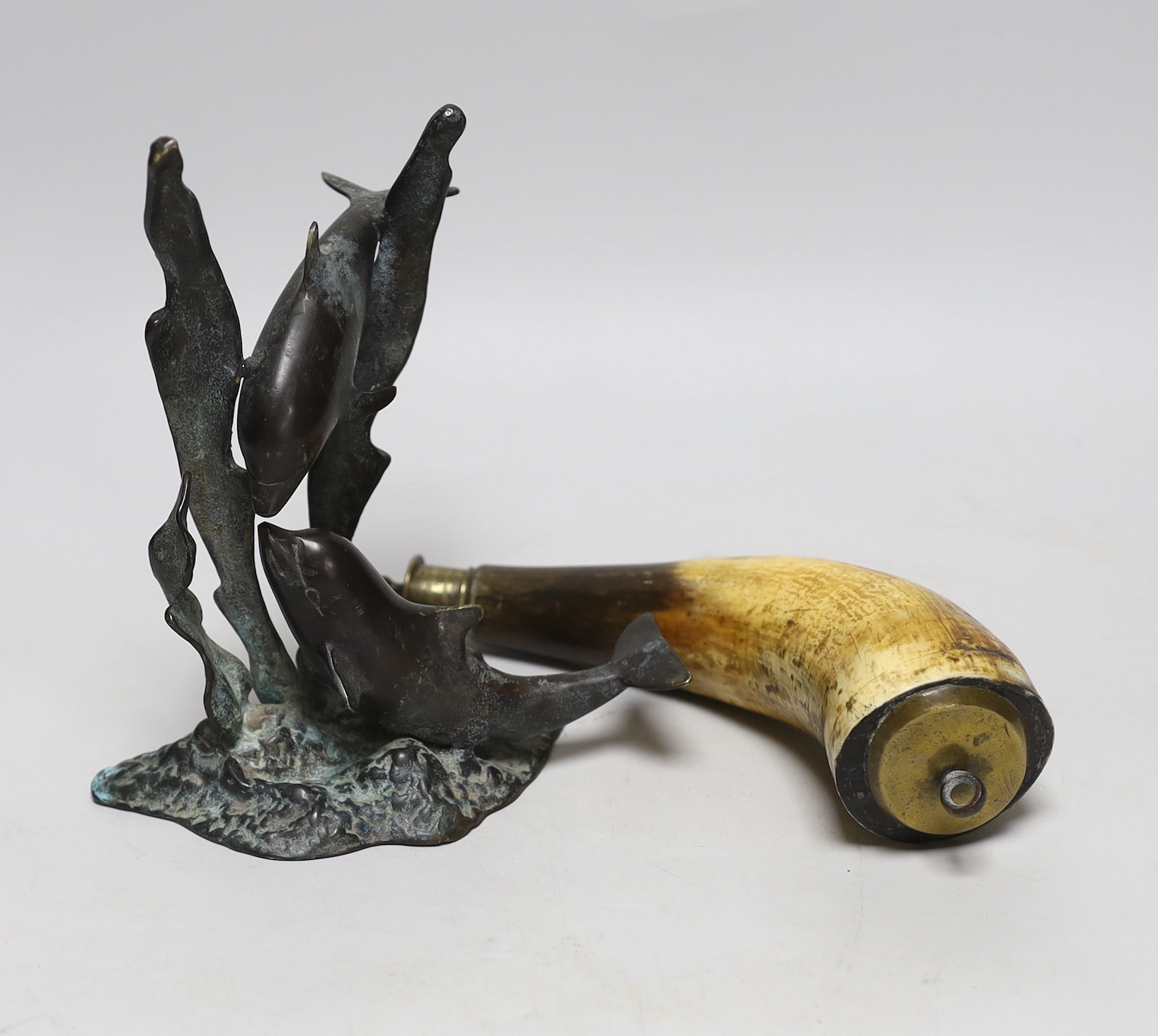 A 19th century powder horn and a cast brass dolphin group, powder horn 23cm long